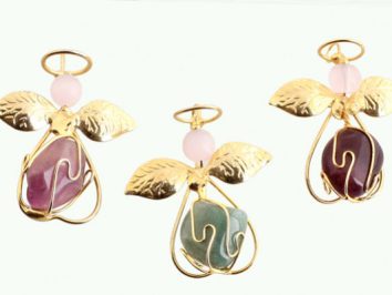 Trzy złote zawieszki w kształcie aniołków z kolorowymi kamieniami i skrzydełkami.