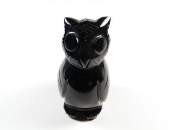 Czarna figurka sowy wykonana z kamienia na białym tle.