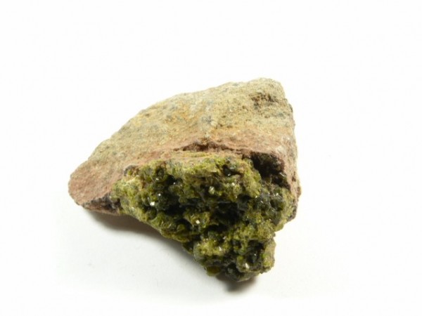 Epidot - kamień naturalny, surowy, nieszlifowany. Kawałek skały z zielonym minerałem o krystalicznej strukturze na białym tle.