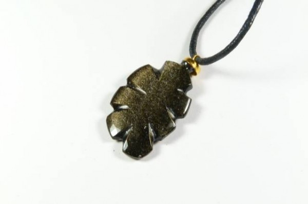 Czarny wisiorek w kształcie liścia na czarnym sznurku, na białym tle.