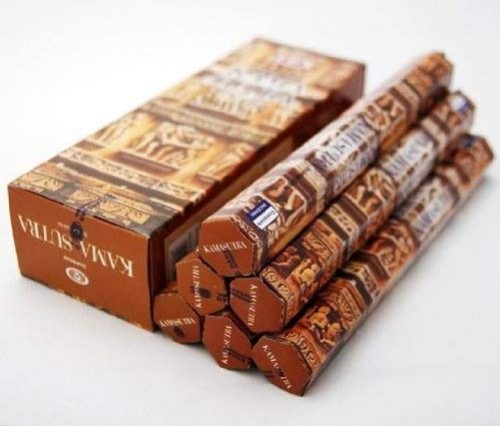 Brązowe opakowania kadzidełek Kamak Sutra ułożone w sześciokątny kształt obok pudełka.