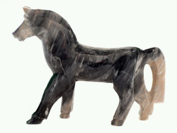 Kamienna figurka konia stojącego w profilu, wykonana z ciemnego marmuru.