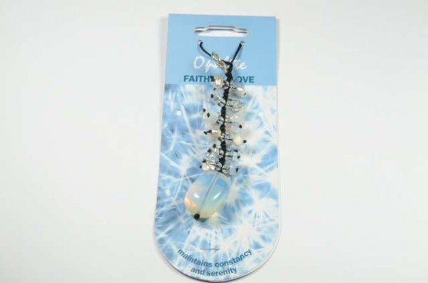 Wisiorek z opalem zawieszony na czarnej nitce, umieszczony na niebieskim kartoniku.