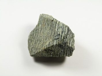 Szara bryła serpentynitu na białym tle.