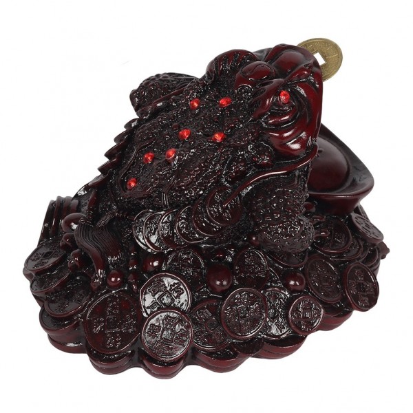 Figurka żaby trzymającej monetę w pysku, siedzącej na stosie chińskich monet.