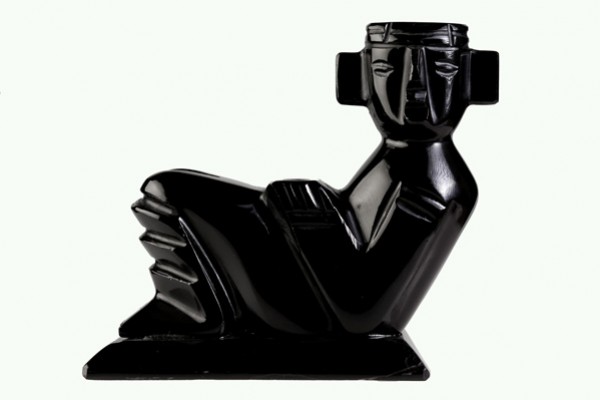 Czarna figurka przedstawiająca leżącego człowieka w stylu azteckim lub prekolumbijskim.