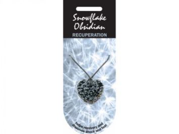 Naszyjnik z obsydianem śnieżnym na tle jasnych świateł, opakowanie z napisem.