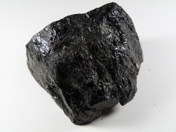 Czarny kawałek węgla kamiennego na białym tle.