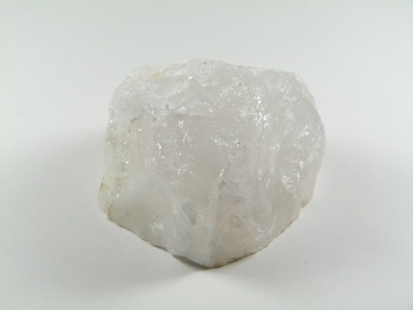 Biały, nieoszlifowany kryształ kwarcu na jasnym tle.