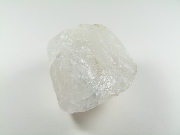 Biały, półprzezroczysty kryształ soli kamiennej na jasnym tle.