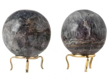 Dwie kulki z kamienia na złotych podstawkach na białym tle.