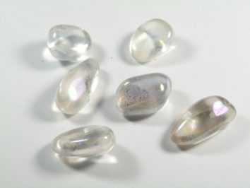 Sześć przezroczystych, wypolerowanych kamieni leży na białym tle.