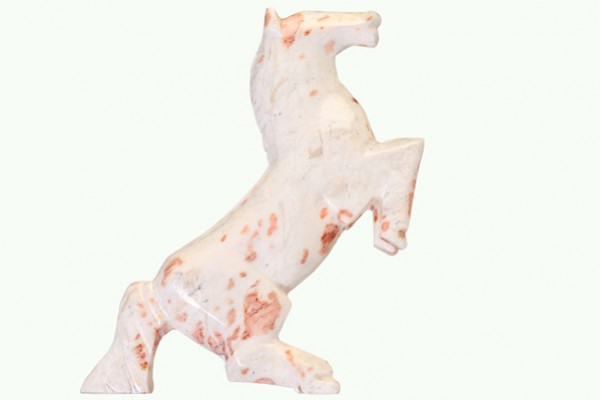 Figurka konia z kamienia, stojącego dęba, w kolorach białym z brązowymi plamkami.