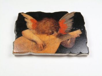 Anioł z rudymi włosami gra na lutni na ciemnym tle, obraz na kawałku kamienia.