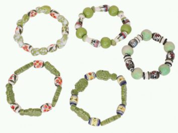 Pięć bransoletek z kolorowych koralików ułożonych na jasnym tle.