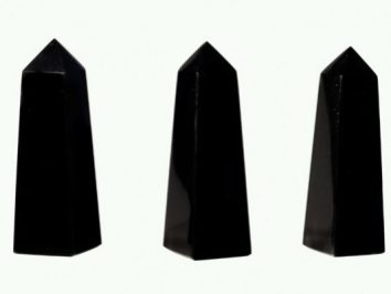 Trzy czarne obeliski ustawione pionowo na białym tle.