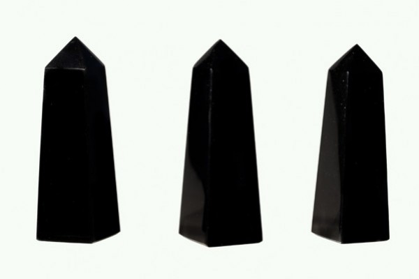 Trzy czarne obeliski ustawione pionowo na białym tle.