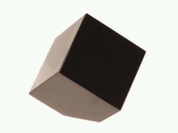 Czarny sześcian unosi się na jasnym tle, widoczny z perspektywy bocznej.