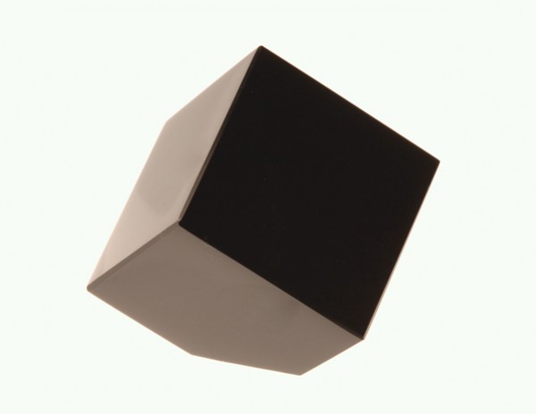 Czarny sześcian unosi się na jasnym tle, widoczny z perspektywy bocznej.