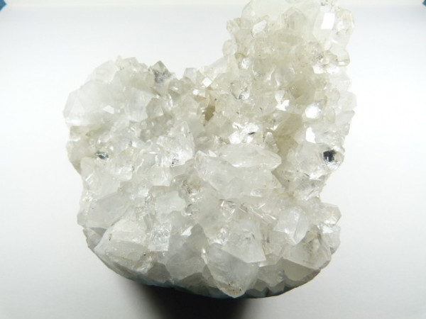 Biała bryła kryształów kwarcu na jasnym tle.