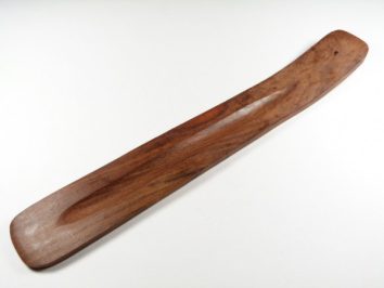 Drewniana łyżka do mieszania lub nakładania potraw, leży na białym tle.