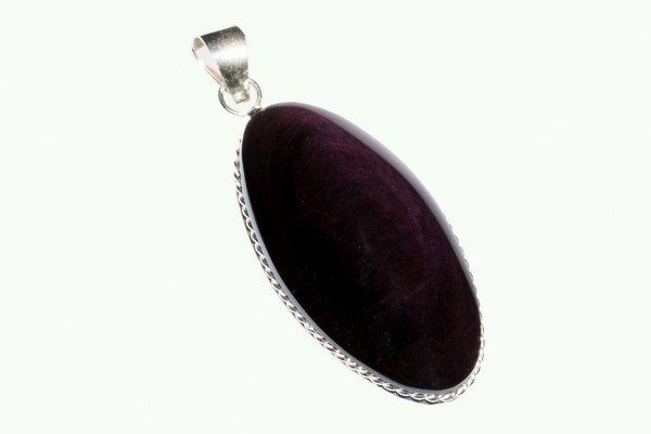 Srebrny wisiorek z dużym owalnym, ciemnofioletowym kamieniem na białym tle.