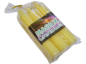 Zestaw żółtych świec opakowany w folię z etykietą „MAGICK CANDLES”.