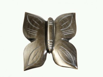 Metalowy motyl o gładkiej powierzchni i geometrycznych wzorach na skrzydłach.