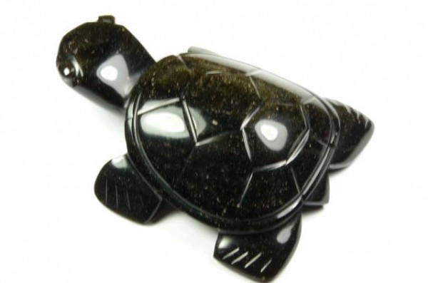 Czarna figurka żółwia wykonana z kamienia, widok z góry na białym tle.