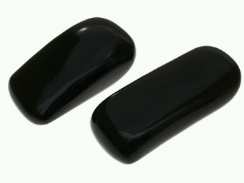 Dwa czarne, gładkie kamienie leżące obok siebie na białym tle.