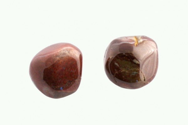 Dwa wypolerowane, brązowe kamienie agatowe na jasnym tle.
