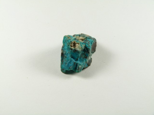 Chryzokola kamień naturalny nieszlifowany surowy. Niebieski kamień minerału turkusu leży na białym tle.