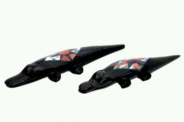 Dwa czarne figurki krokodyli z kolorowymi wzorami na grzbietach, ustawione obok siebie.