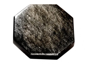 Czarny, ośmiokątny kamień szlachetny o błyszczącej powierzchni na białym tle.