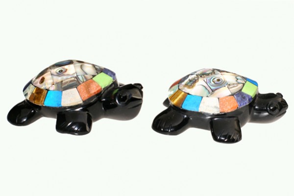 Dwie kolorowe figurki żółwi z mozaikowymi skorupami ustawione obok siebie na białym tle.