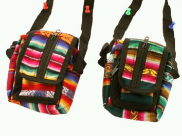 Dwie kolorowe torebki na ramię z etnicznym wzorem wiszą na haczykach.