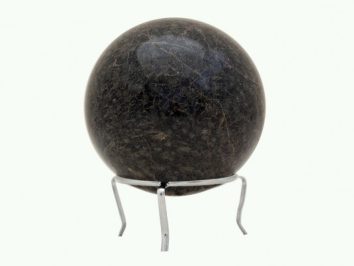 Czarna kula z kamienia umieszczona na metalowym stojaku na białym tle.