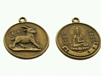 Dwa okrągłe medaliony z brązu z wizerunkiem kozy i postacią buddyjską oraz chińskimi napisami.