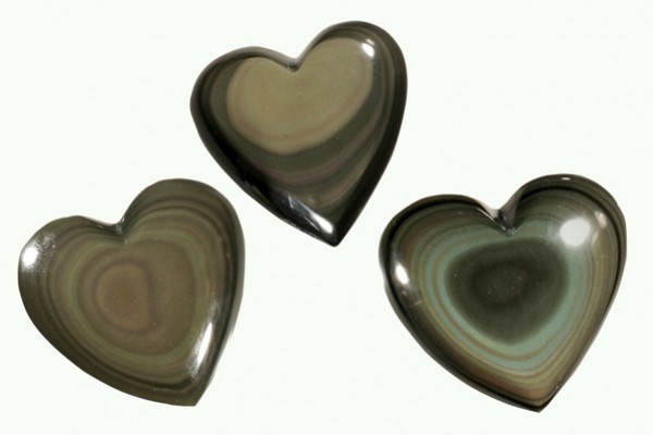 Trzy kamienie w kształcie serca z szarego obsydianu, ułożone na jasnym tle.