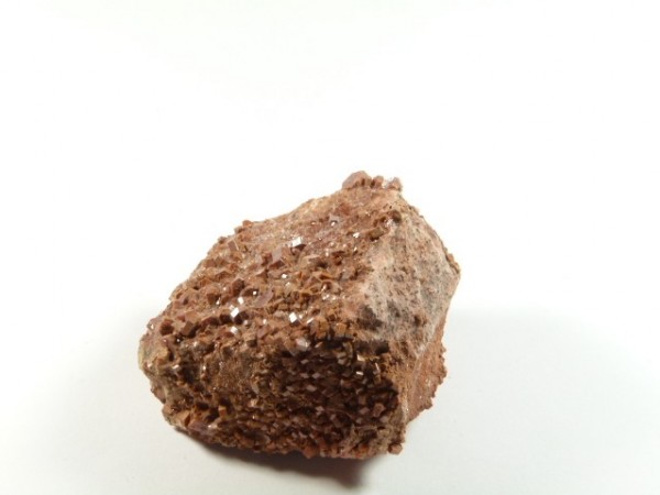 Wanadynit - kamień naturalny, surowy, nieszlifowany. Brązowy minerał z drobnymi kryształkami na białym tle.