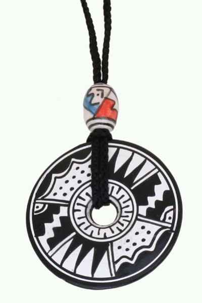 Czarnobiały wisiorek z geometrycznym wzorem, zawieszony na sznurku z ozdobnym koralikiem.