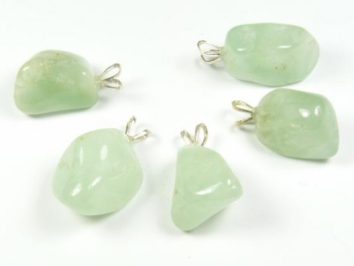 Pięć zielonych kamieni z zawieszkami do noszenia na łańcuszku, ułożonych na białym tle.