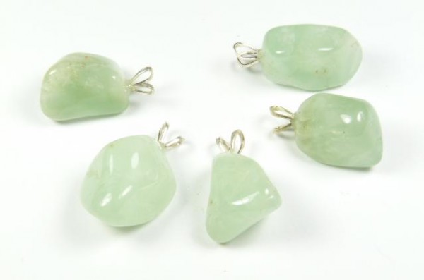 Pięć zielonych kamieni z zawieszkami do noszenia na łańcuszku, ułożonych na białym tle.
