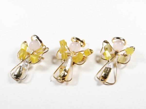 Trzy ozdobne aniołki z drutu i koralików na białym tle.