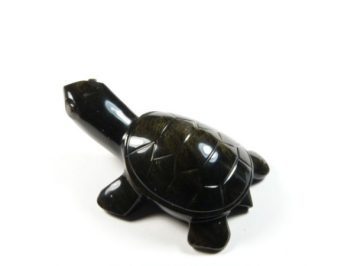 Czarna figurka żółwia wykonana z kamienia na białym tle.