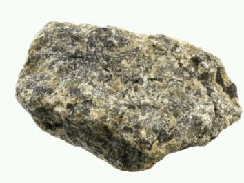 Labradoryt - kamień naturalny, surowy, nieszlifowany. Szara, nieregularna bryła kamienia na jasnym tle.