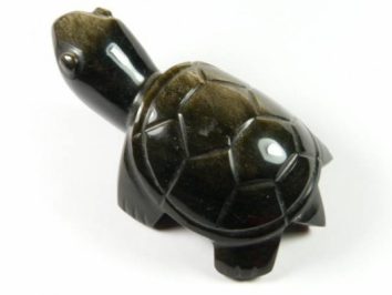 Czarna figurka żółwia z kamienia na białym tle.