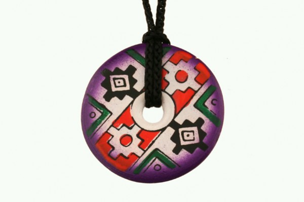 Okrągły wisiorek z kolorowym, geometrycznym wzorem na czarnym sznurku.