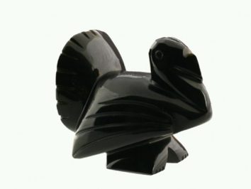 Czarna figurka indyka wykonana z kamienia, widoczna na jasnym tle.