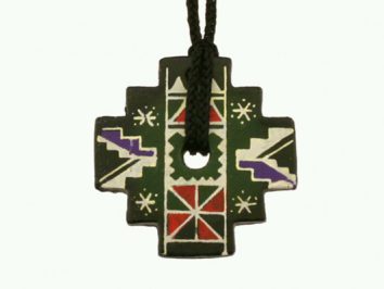 Wisiorek w kształcie krzyża z kolorowymi, geometrycznymi wzorami i czarnym sznurkiem.